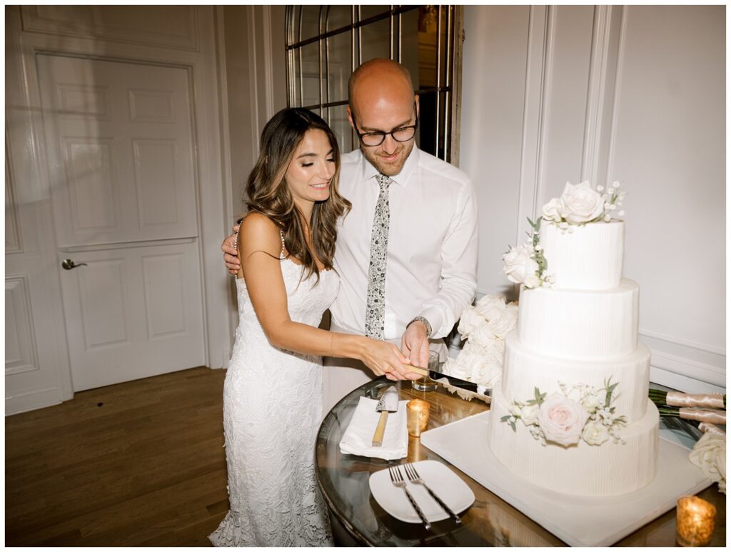 bride and groom cut their cake at indoor reception at Bear Brook Valley