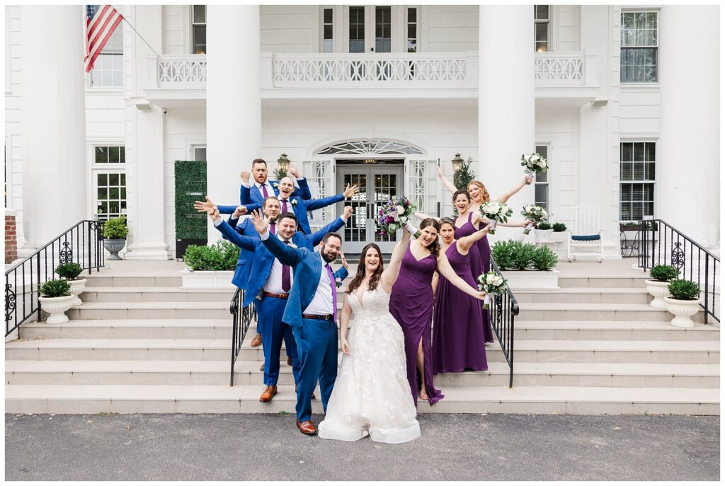 full bridal party posing on the front steps of Briarcliff Manor in New York