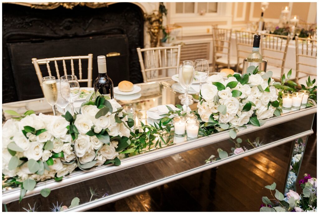 couple's sweetheart table decorated with white flowers and candles 