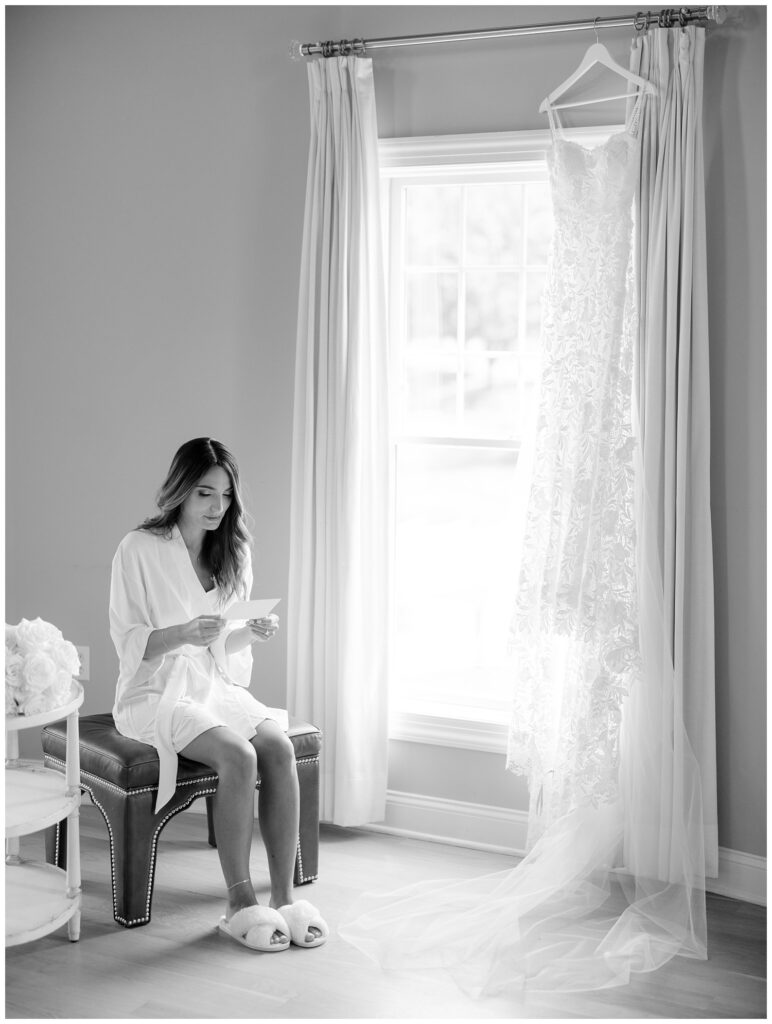 bride wearing a white robe reading a letter from her spouse to be in New Jersey