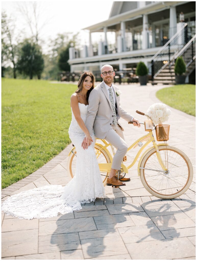 wedding couple posing on a yellow bike at the front of the wedding venue in New Jersey