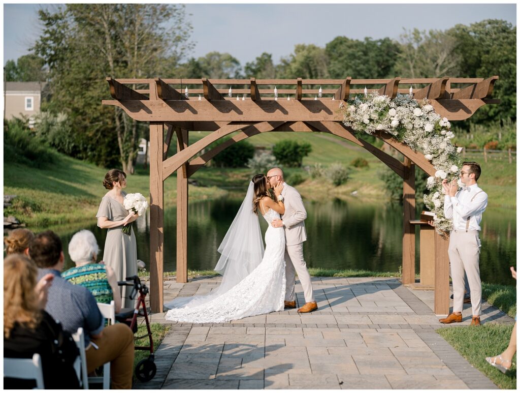 wedding couple kissing at the end of the outdoor ceremony at Bear Brook Valley