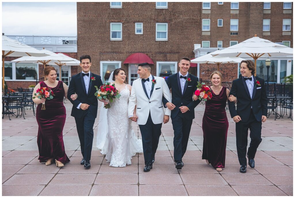 full wedding party linked in arms walking together at an Asbury Park wedding venue