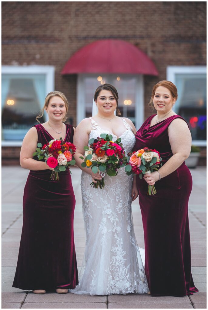 bride posing with bridesmaids at fall wedding in Asbury Park