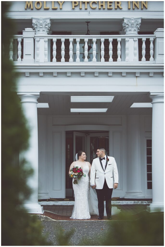 wedding couple standing on the front porch of The Molly Pitcher Inn venue