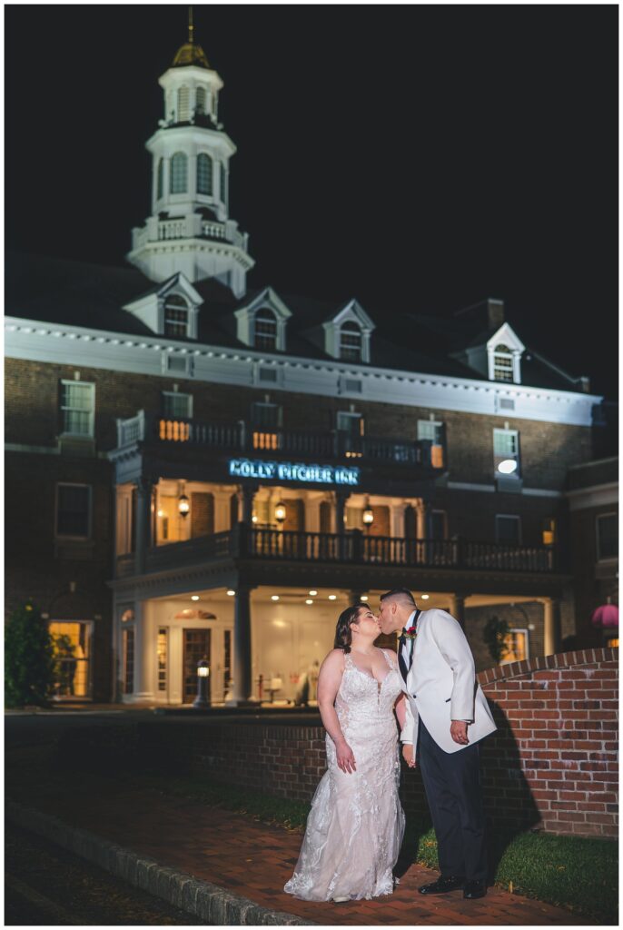 bride and groom standing outside the wedding venue for night time portraits 
