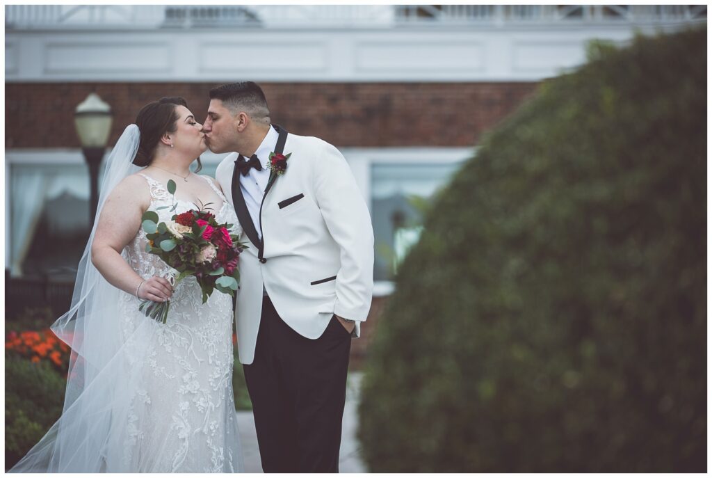 wedding couple kiss during couples portraits at venue in Asbury Park