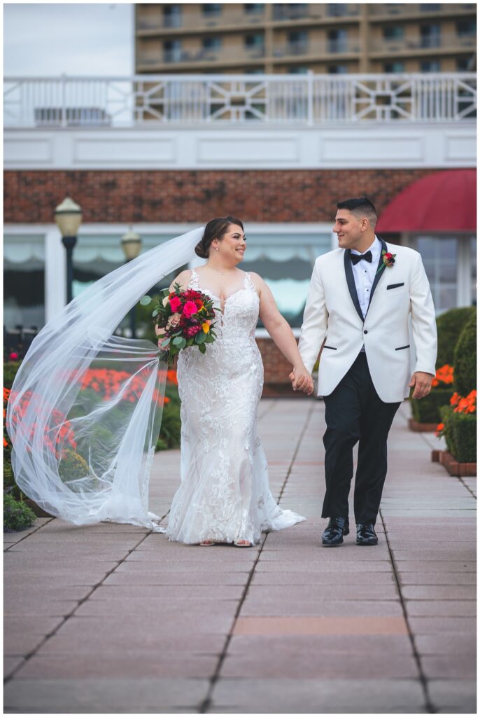 wedding couple holding hands and walking together outside 