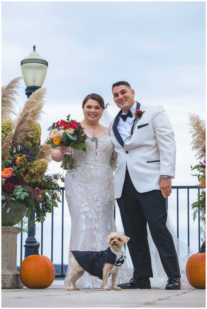 bride and groom posing with their dog at Asbury Park wedding venue