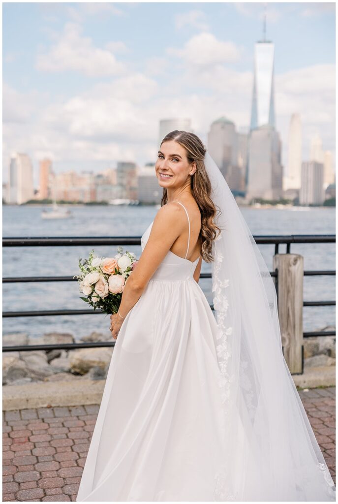 bride turned to show off her veil and the back of her dress next the Hudson River in Jersey City