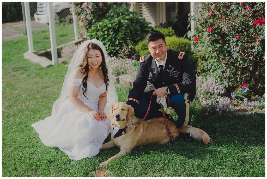 wedding couple posing with their golden retriever outside before the ceremony