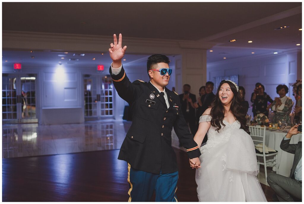 groom and bride making their entrance into the reception with groom wearing sunglasses