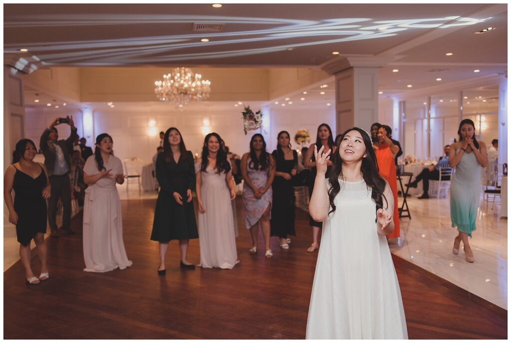 bride tossing back her bouquet at Grand Oaks Country Club reception