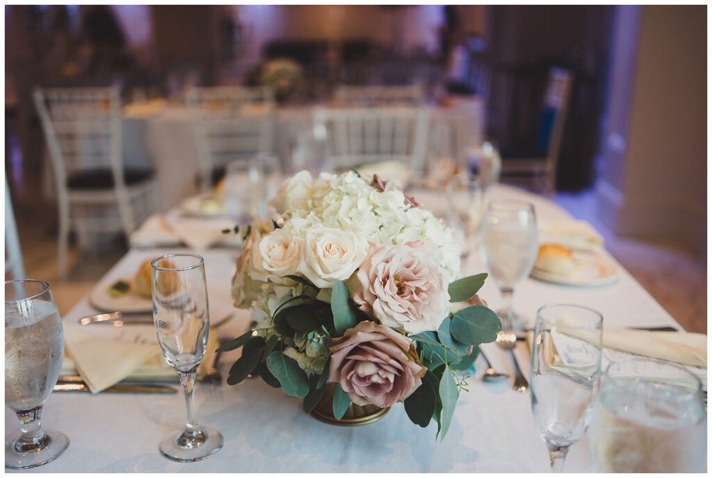 white, pink, and light purple roses in the centerpieces of reception tables in New York