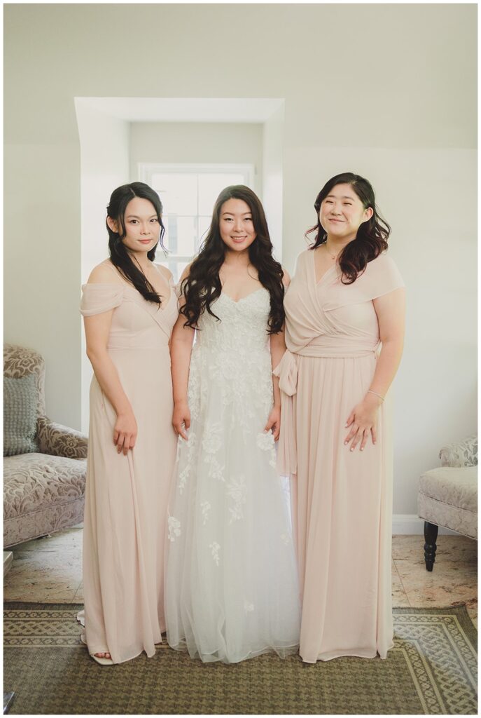 bride posing with her bridesmaids while getting ready for wedding 