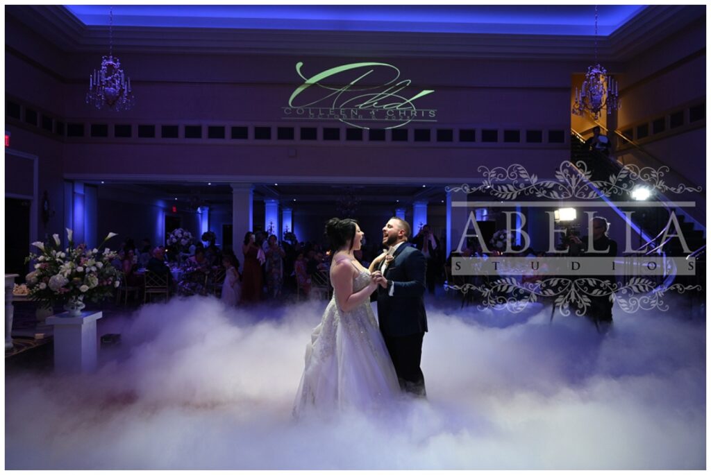 bride and groom have official first dance surrounded by fog on the wood floor 