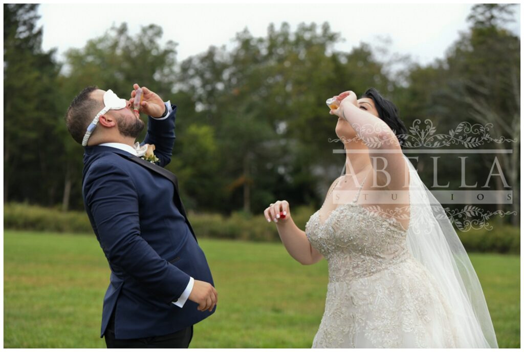 groom and bride sharing a shot together before the wedding outside 