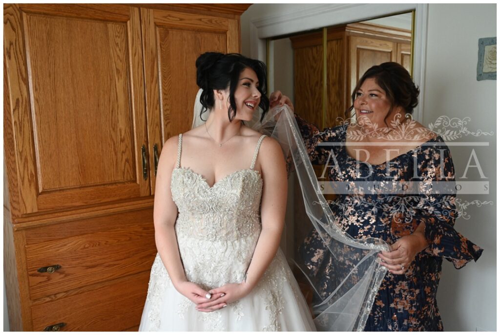 bride's mom helping bride put on her veil at New Jersey wedding